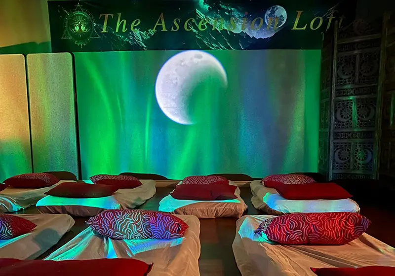 Floor mattresses and atmospheric green lighting at The Ascension Loft — intimate group energy healing space in Abbotsford BC